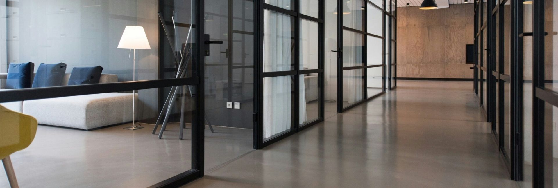Contemporary hotel lounge featuring yellow chairs and cityscape view through large windows.